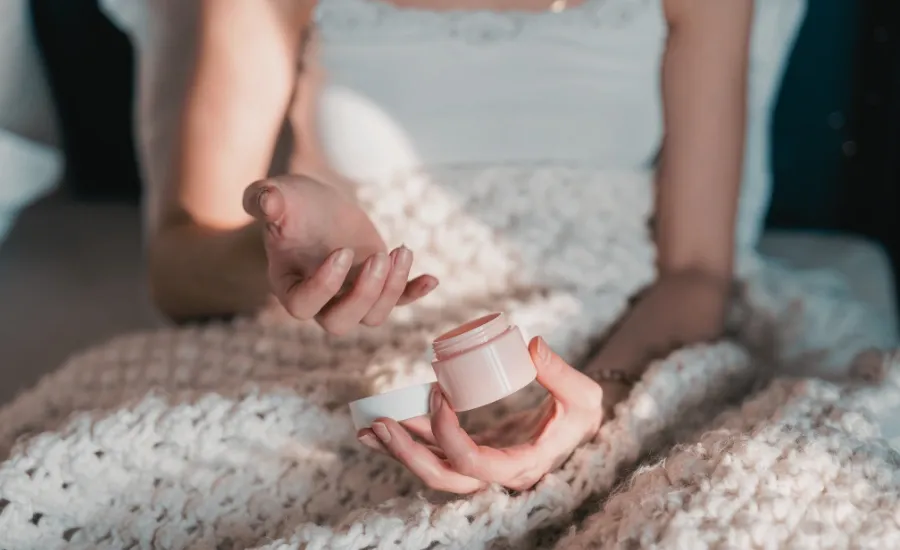 woman holding her new moisturizer to apply it in her face