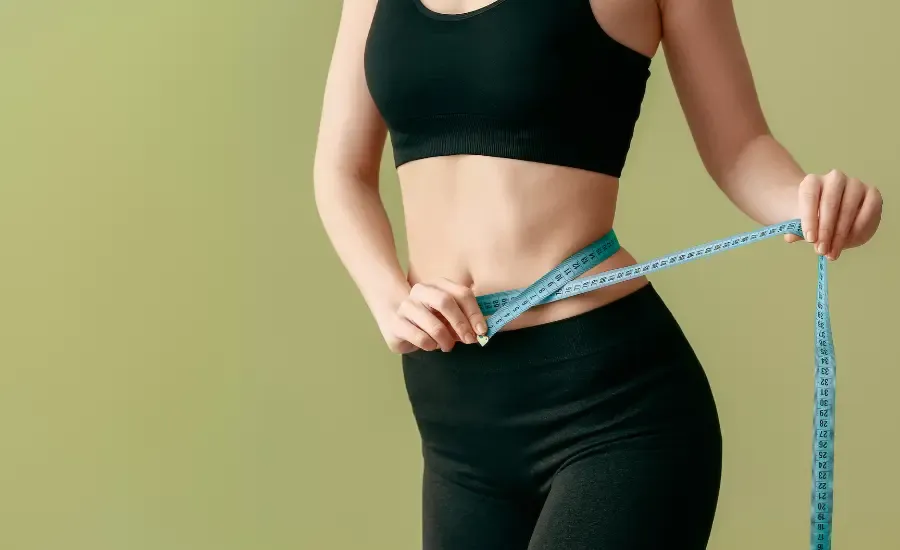 woman with tape measurer in her belly