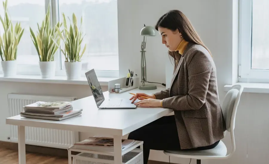 woman sitting in her desk and work on her laptop