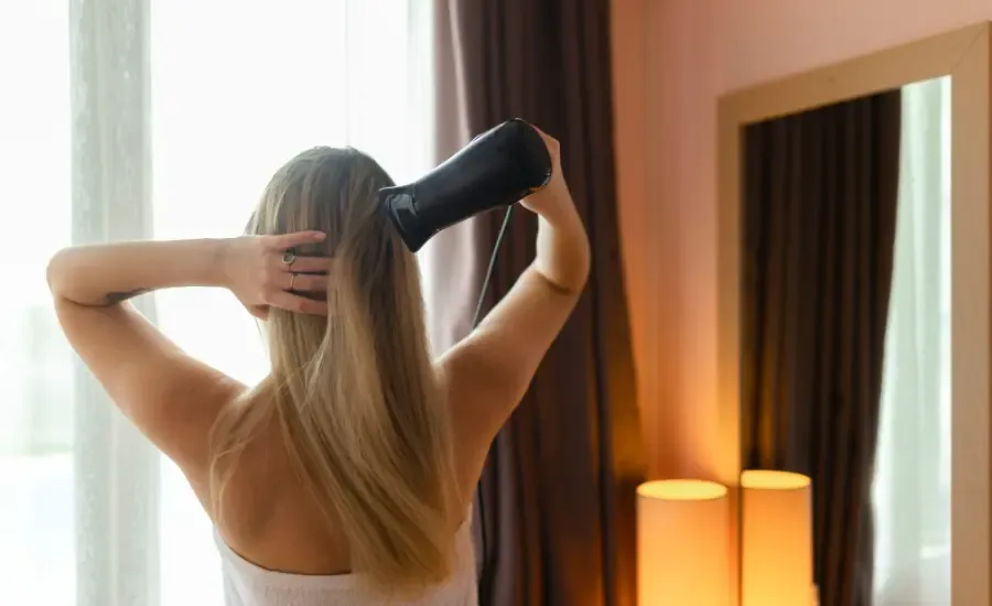woman blow drying her hair